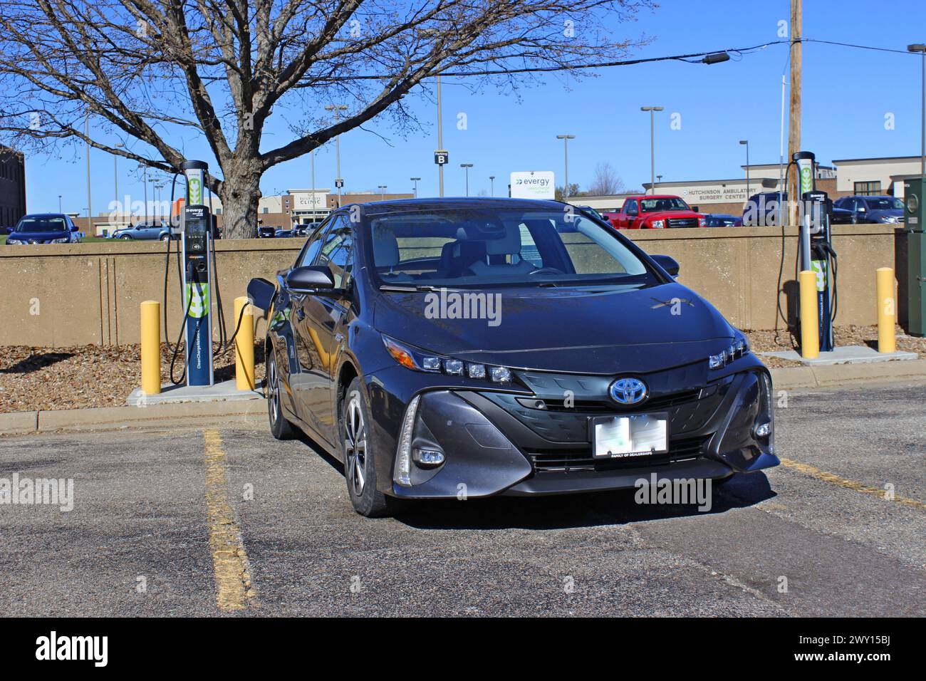 Toyota Elektroauto lädt auf einem alltäglichen Ladegerät draußen auf dem Parkplatz auf Stockfoto