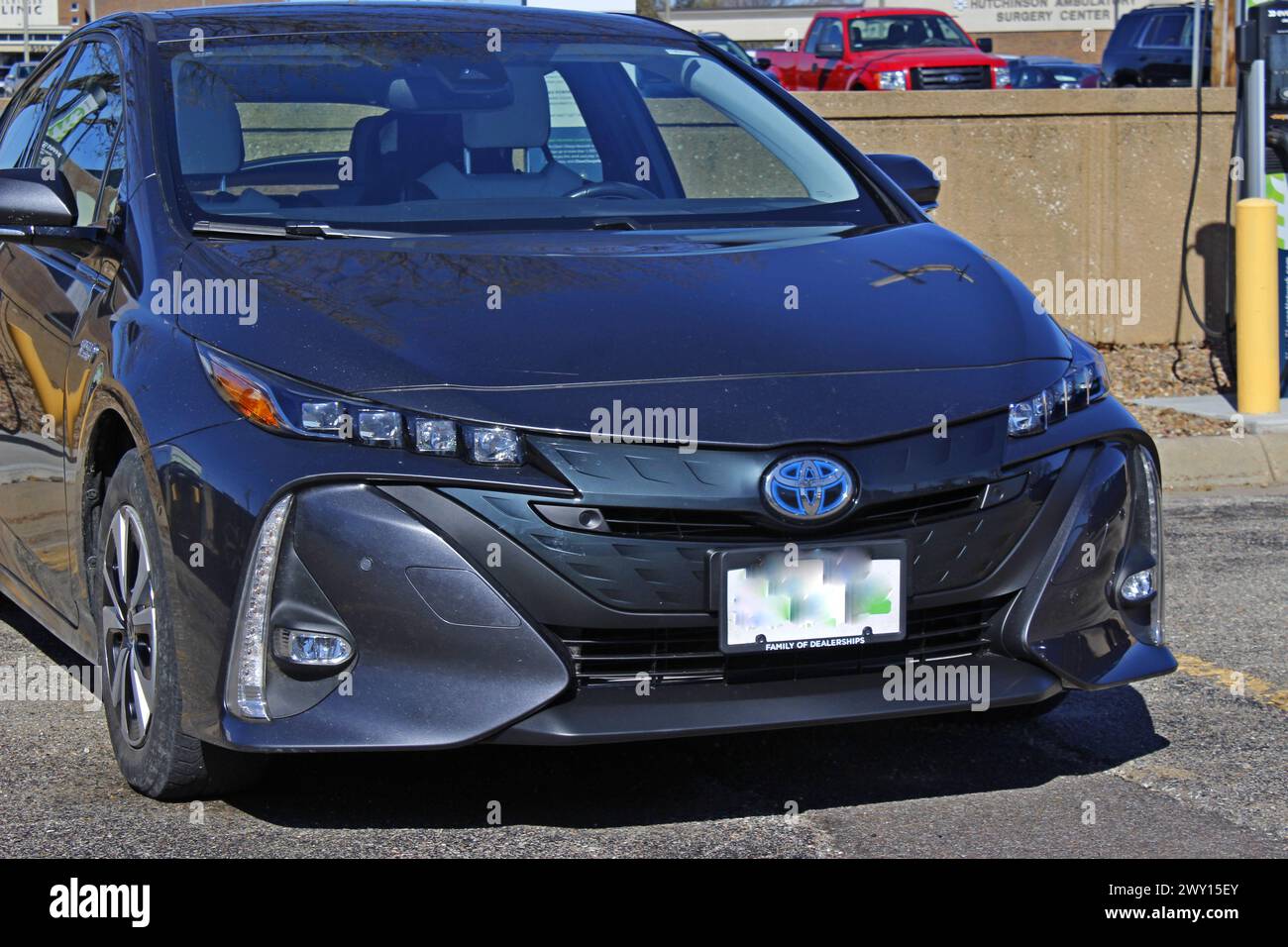 Toyota Elektroauto lädt auf einem alltäglichen Ladegerät draußen auf dem Parkplatz auf Stockfoto