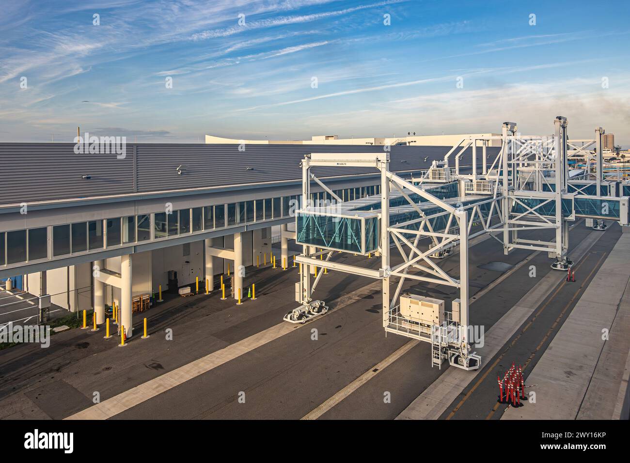 Port Canaveral, Florida, USA - 30. Juli 2023: Kreuzfahrtterminal 1 fahrgastbestückte bewegliche Brücke am Kai, vor dem Terminal unter blauer Wolkenlandschaft Stockfoto