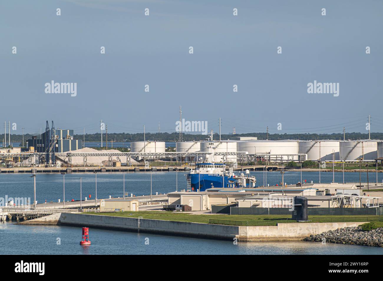 Port Canaveral, Florida, USA - 30. Juli 2023: Northstar Responder Verschmutzungsschutzschiff zwischen Seaport Tanks und NOTU Marinebasis unter blauem Himmel Stockfoto