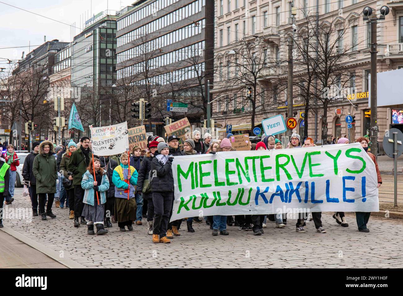 Leute mit Banner und Schildern marschieren auf Mannerheimintie im Mielenterveys Kuuluu Kaikille! Demonstration in Helsinki, Finnland Stockfoto