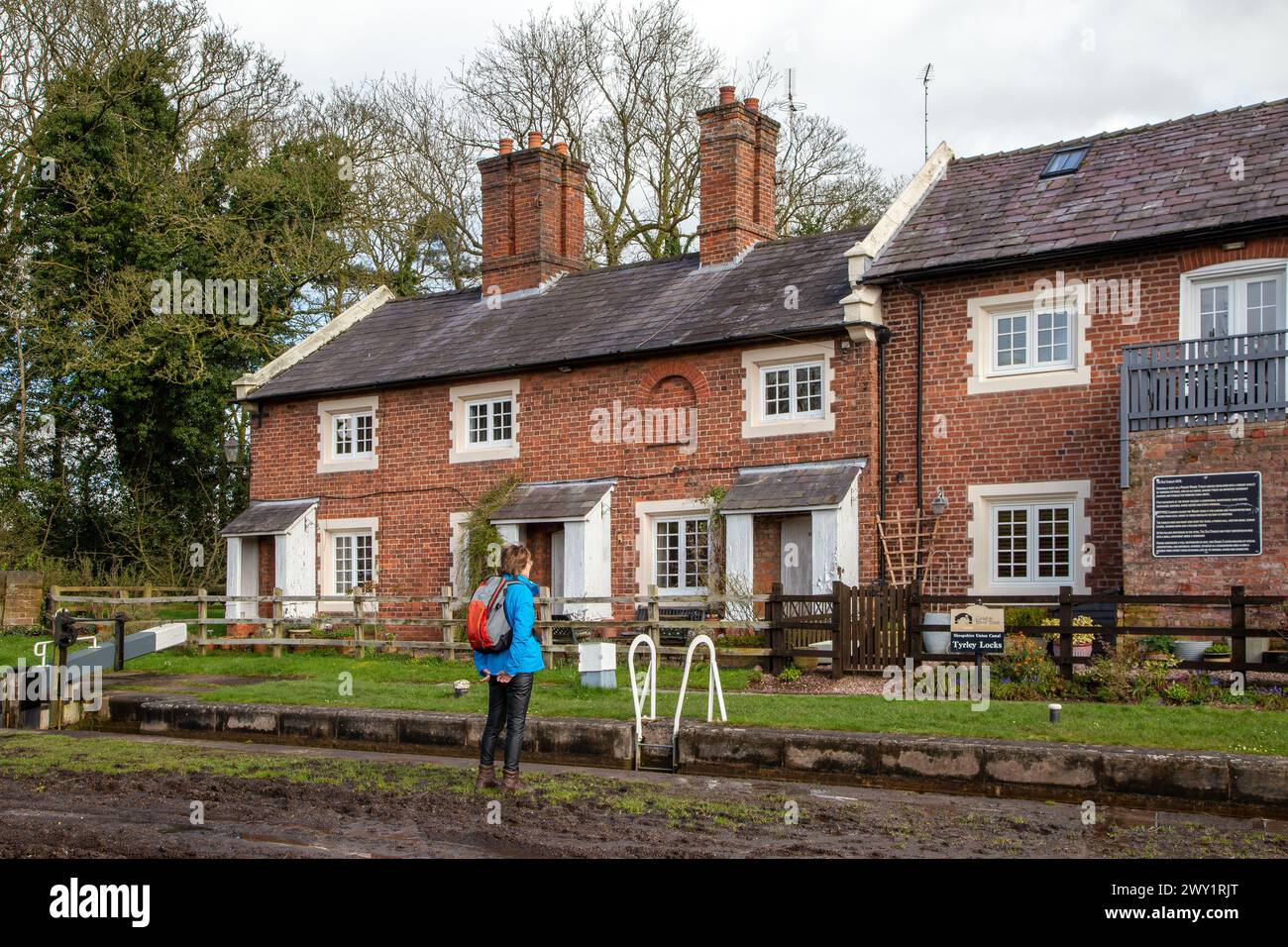 Frau, die die Schleusenhütten am Shropshire union Kanal beobachtet, als er durch Tyrley Locks in der Nähe des Markts Drayton Shropshire England führt Stockfoto