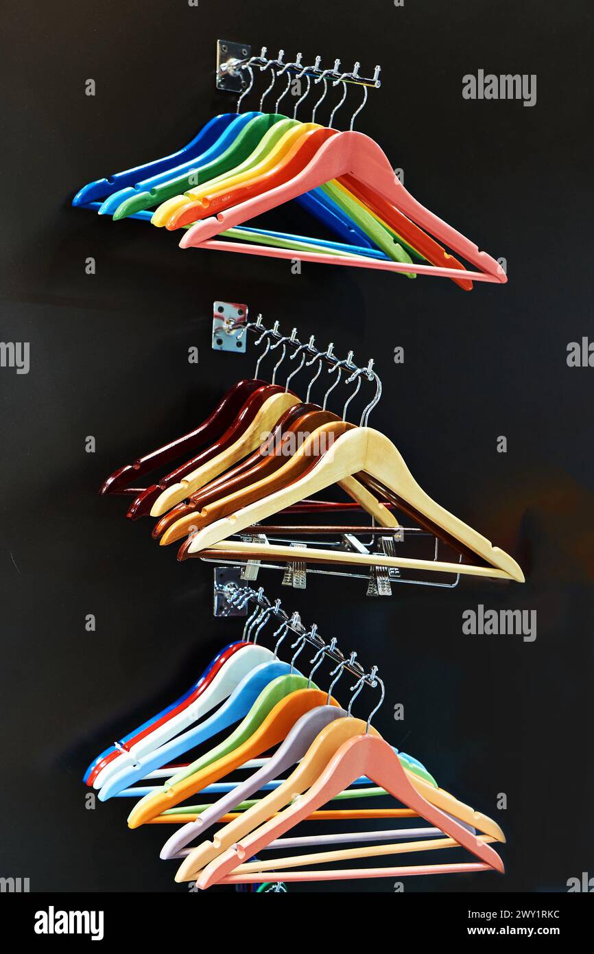 Bunte Kleiderbügel an Kleiderstange im Laden Stockfoto