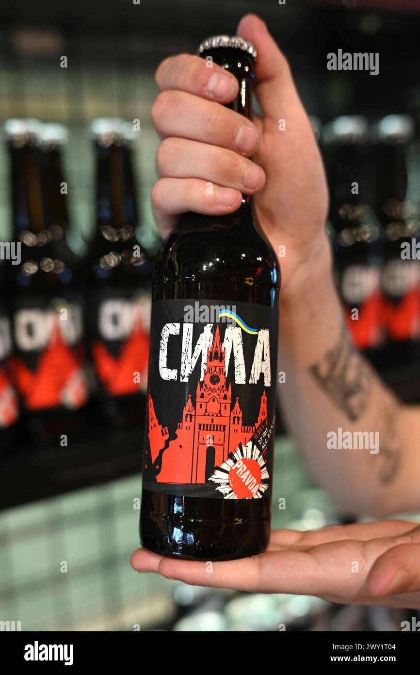 Lemberg, Ukraine - 2. April 2024: Ein Schuss lokales gebrautes Bier namens Power mit Etikett, das einen zerstörten Moskauer Kreml mit Flagge der Ukraine darstellt. Stockfoto