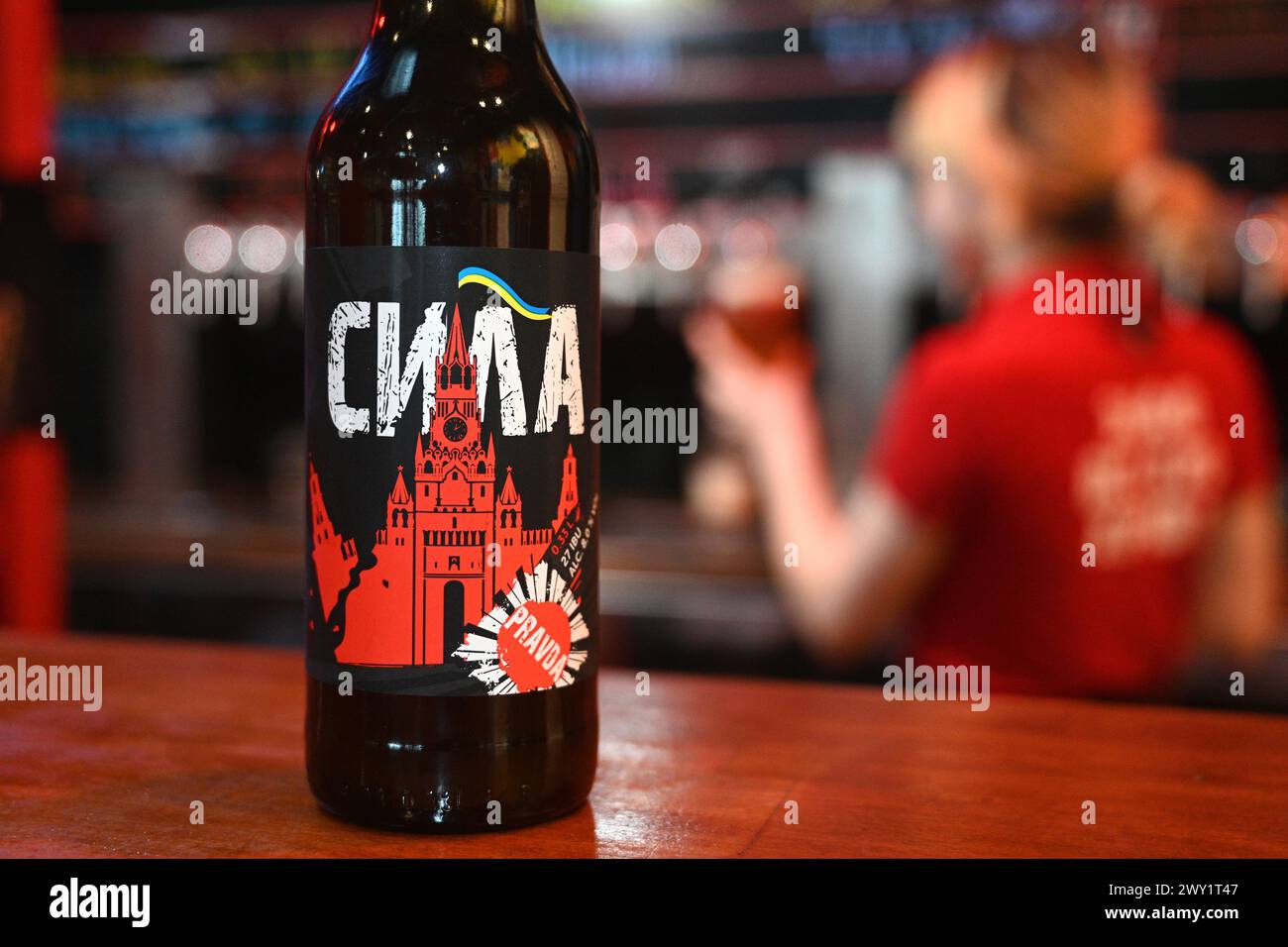 Lemberg, Ukraine - 2. April 2024: Ein Schuss lokales gebrautes Bier namens Power mit Etikett, das einen zerstörten Moskauer Kreml mit Flagge der Ukraine darstellt. Stockfoto