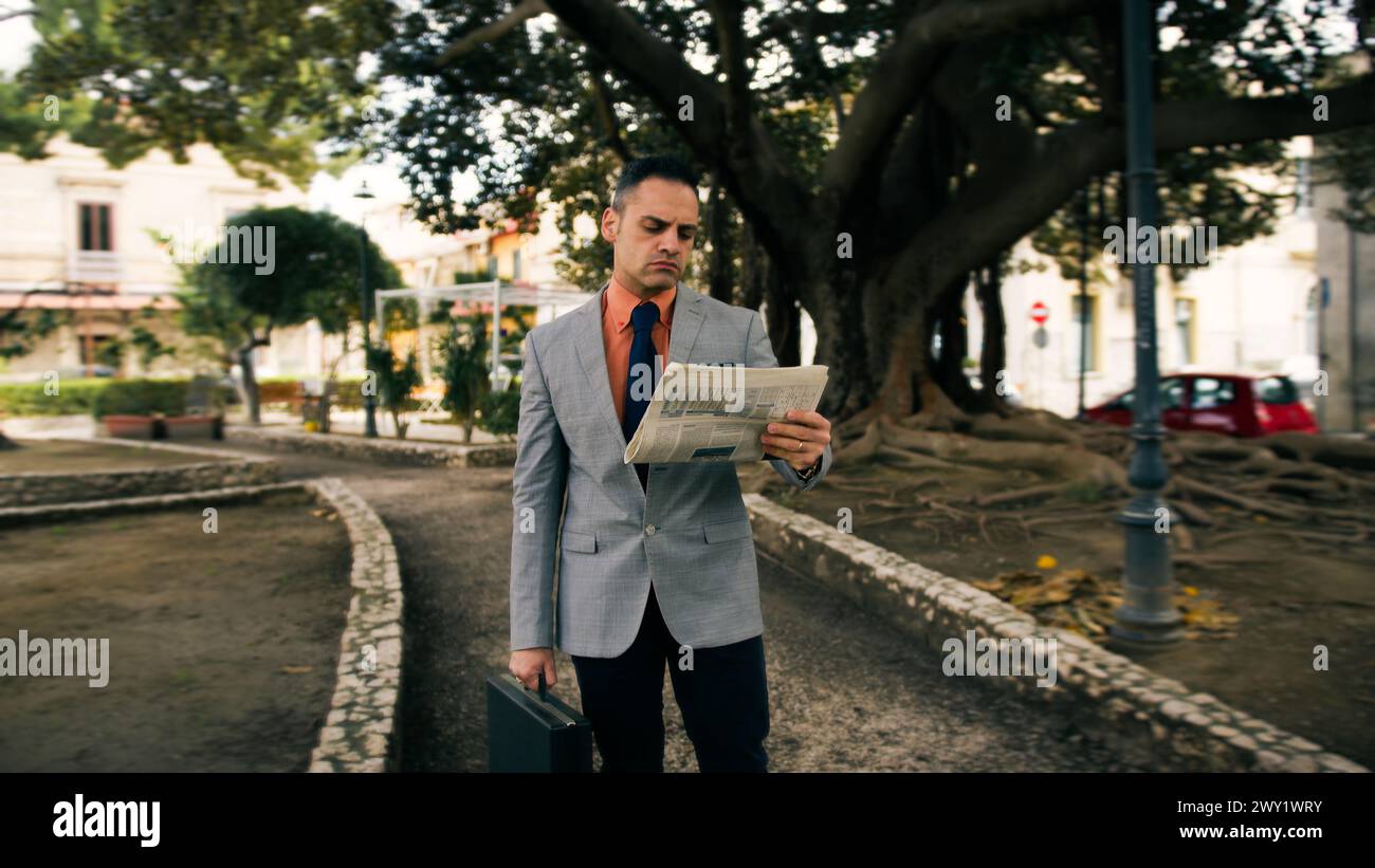 Geschäftsmann mit Aktenkoffer und Zeitung Stockfoto
