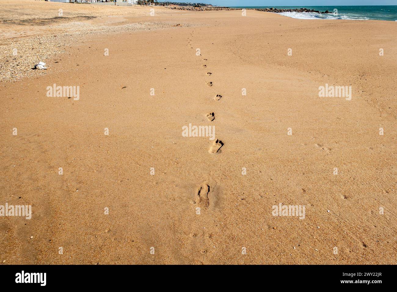 Abgelegene Fußgängerwege in die Ferne an diesem Sandstrand von Quarteira, Portugal. Stockfoto