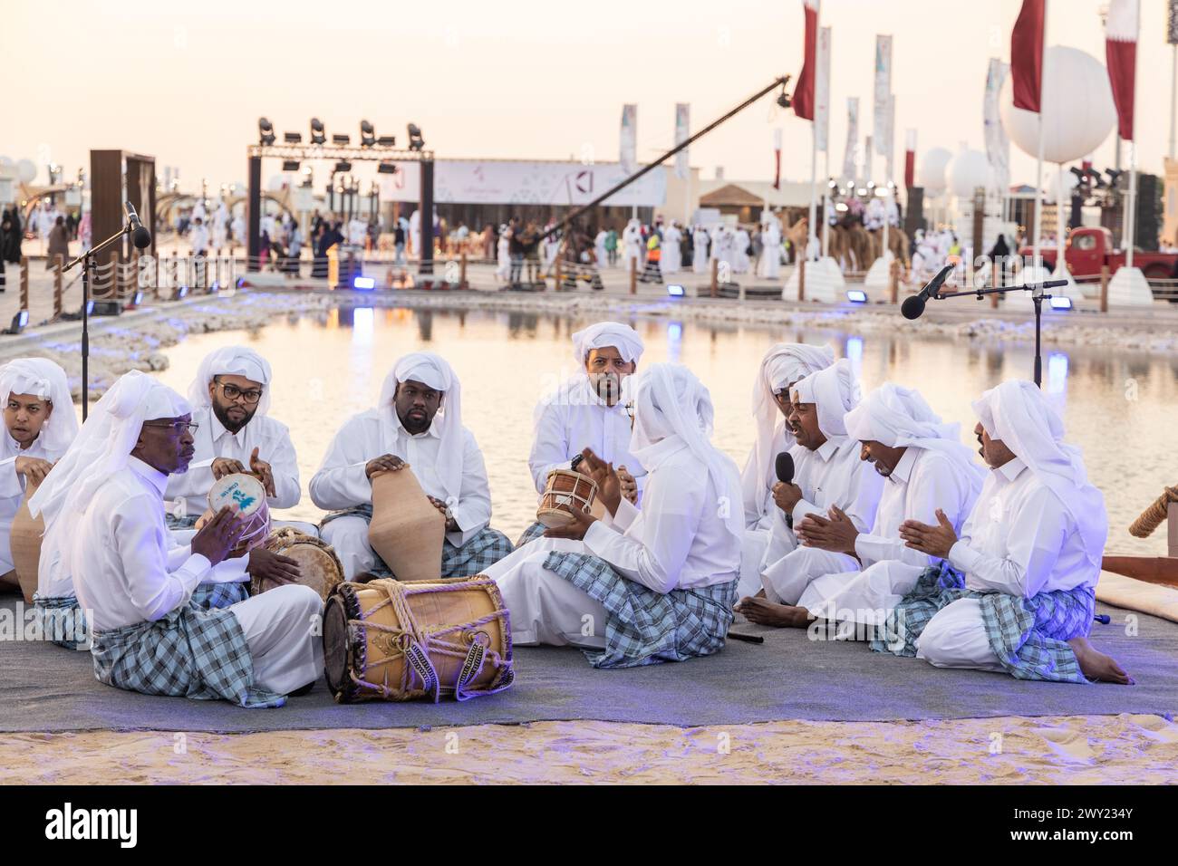 Eine katarische Band mit traditioneller Kleidung, die ein Musikinstrument aus dem katarischen Erbe spielt und den Nationalfeiertag von Katar feiert Stockfoto