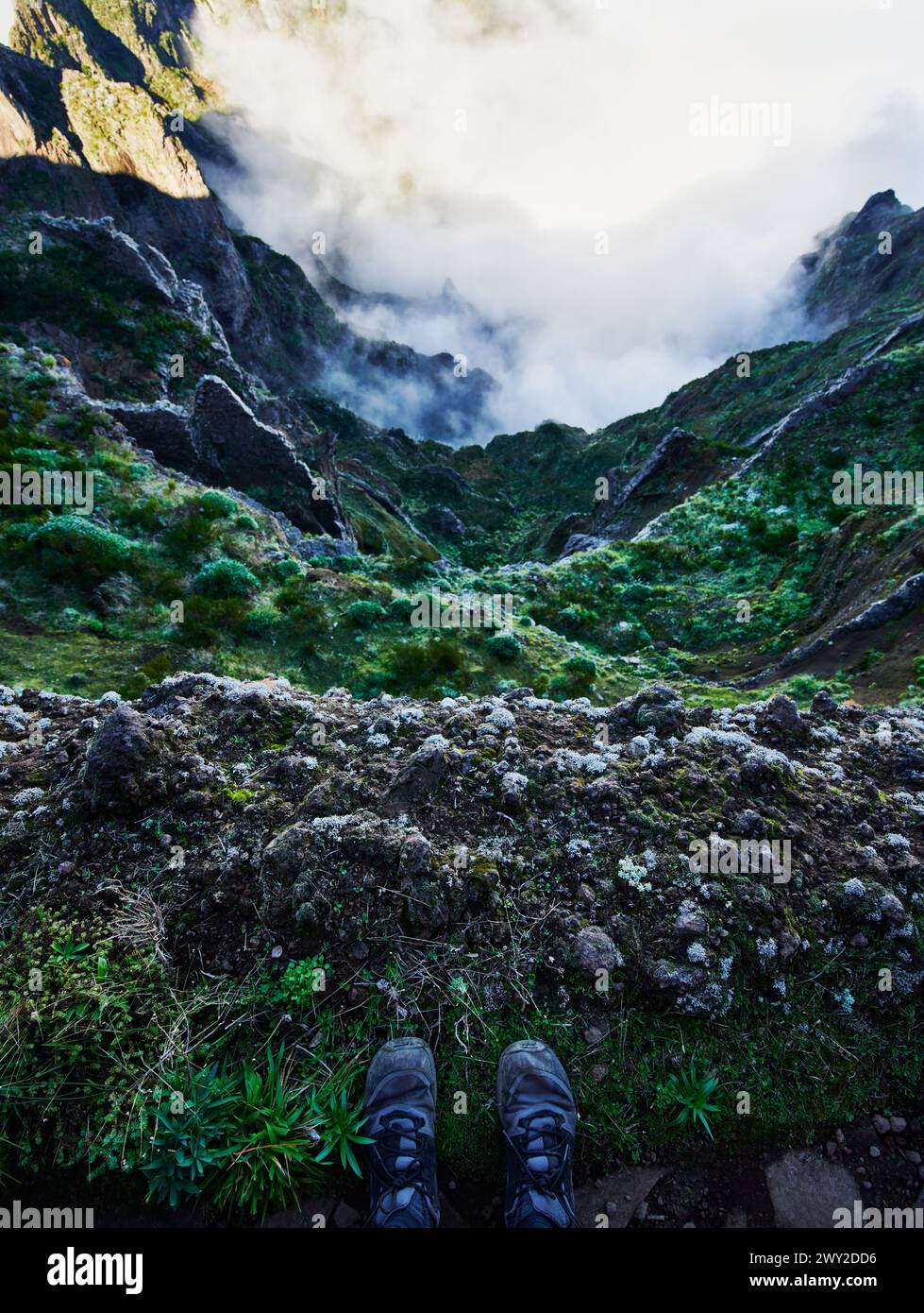 Wanderer Füße mit Blick auf die Berglandschaft von Pico do Arierio zur Pico Ruivo Wanderung (PR1) auf Madeira Insel, Portugal, Europa Stockfoto