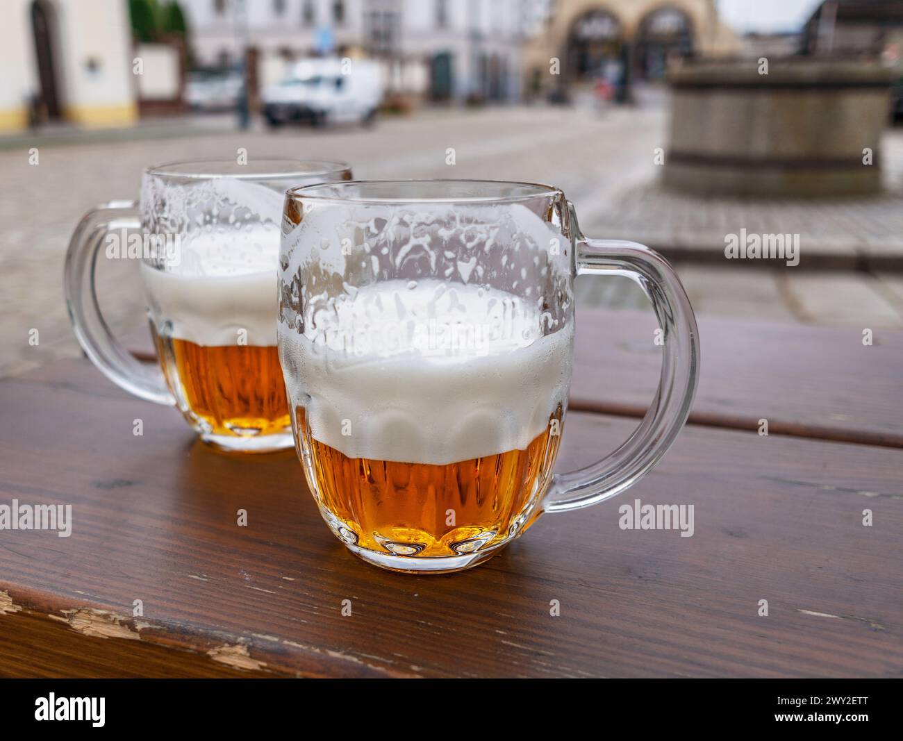 Bierbecher oder Biergläser auf Holztisch Stadt im Hintergrund. Stockfoto