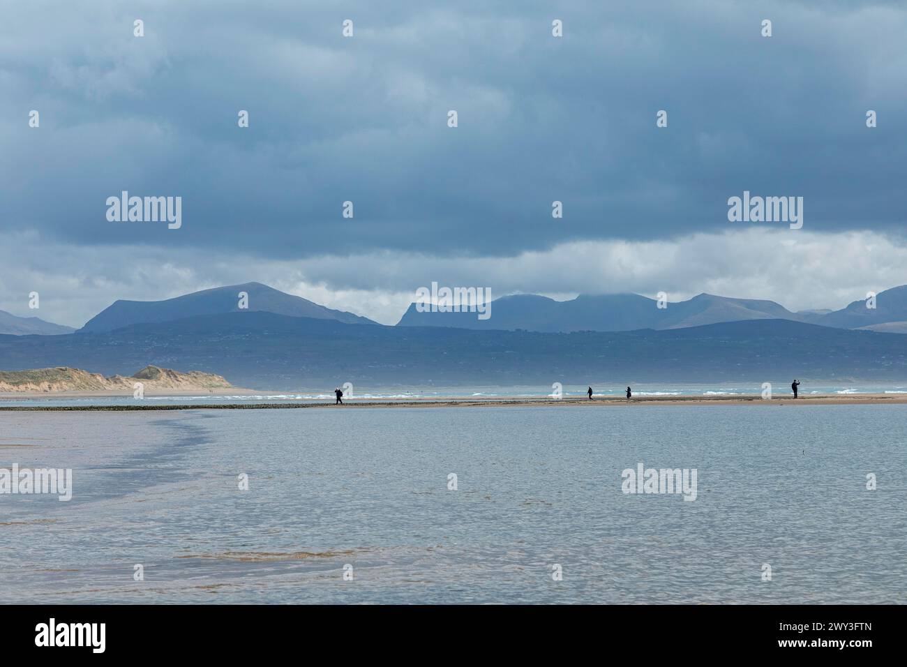 Strand, Menschen, Wolken, Berge, LLanddwyn Bay, Newborough, Isle of Anglesey, Wales, Großbritannien Stockfoto