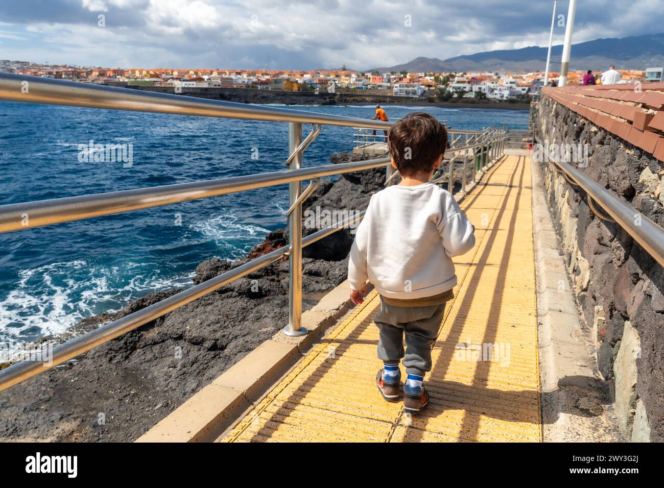 Junge lächelt im Sommerurlaub am Meer und geht zum Wasser Stockfoto