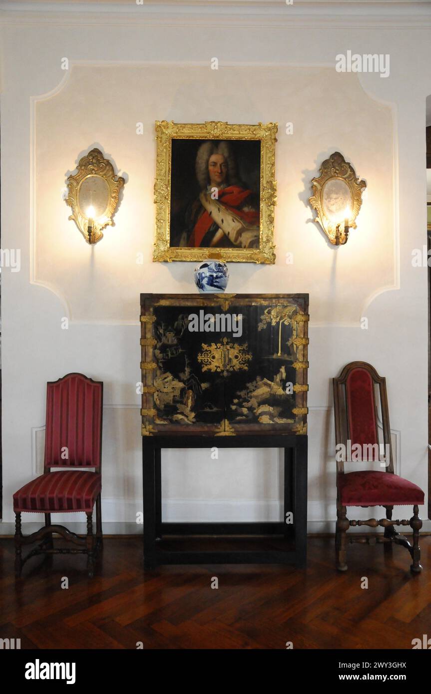 Schloss Langenburg, klassisches Interieur mit Porträtmalerei und Kerzenleuchtern an der Wand und zwei roten Stühlen, Schloss Langenburg, Langenburg Stockfoto