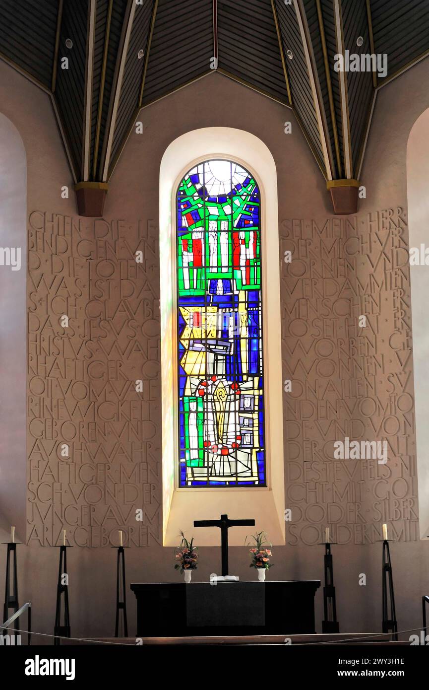 Speyerer Dom, kleiner Altar mit Kreuz vor einem großen Buntglasfenster und Wand mit einem Reliefrelief der Schrift, Speyerer Dom, UNESCO-Welt Stockfoto