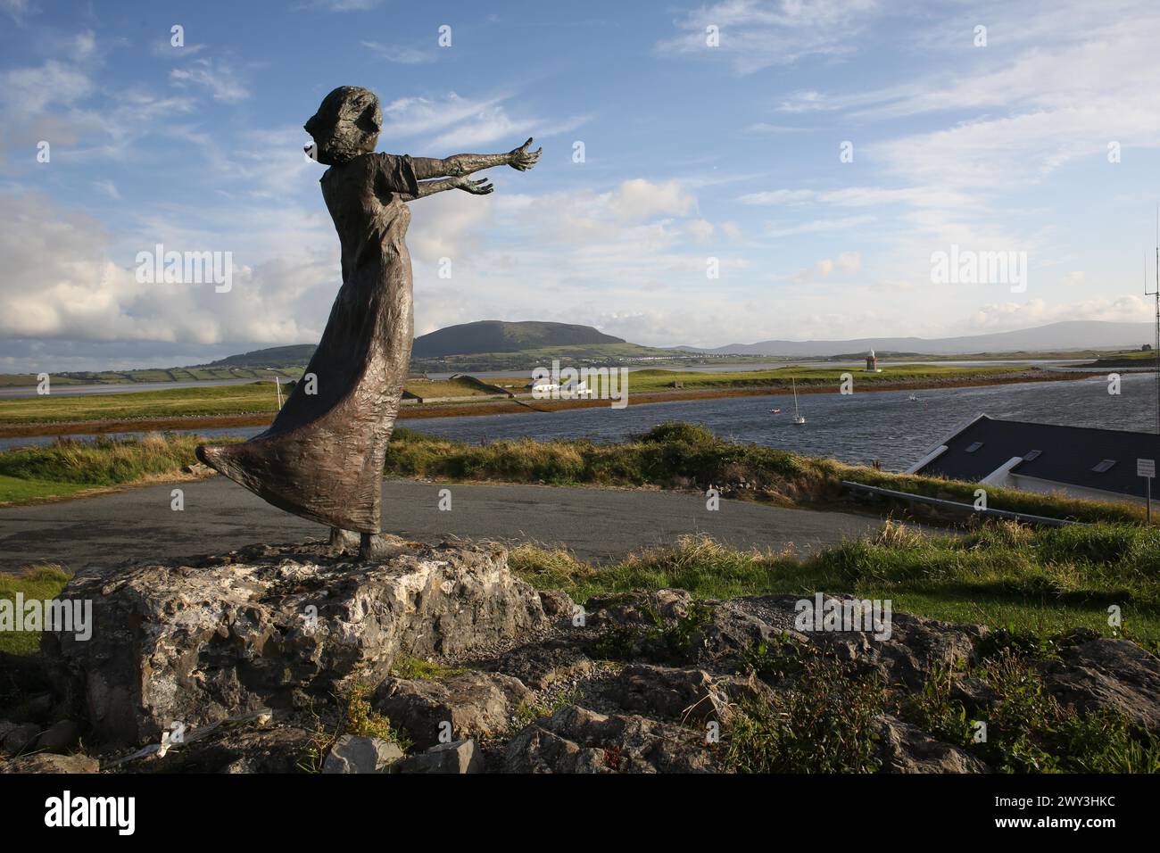 Eine Aufnahme von Niall Brutons Statue, die am Ufer wartet und eine Frau mit ausgestreckten Armen zeigt, um die Seefahrer zu erkennen Stockfoto