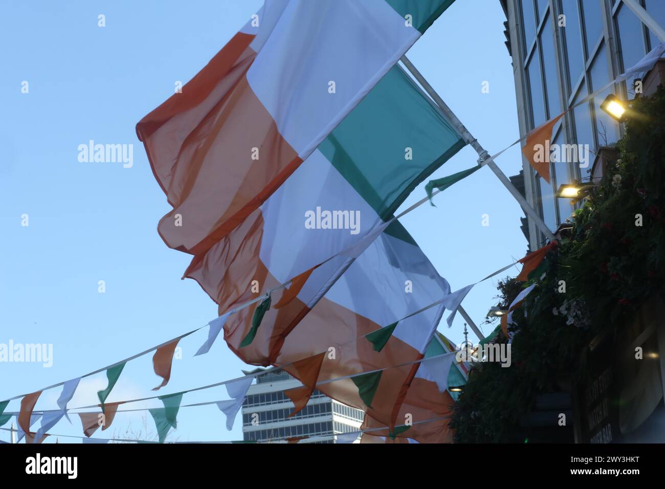 Die irischen Trikolore hängen an einem sonnigen Tag in der Brise. Dublin, Irland Stockfoto