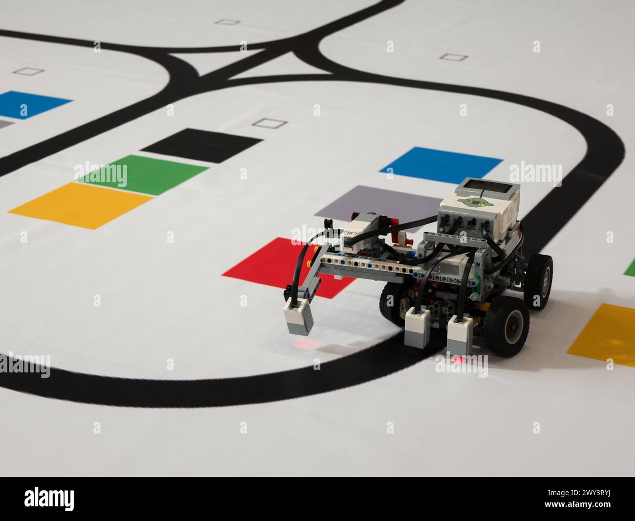 Roboter mit Rädern bewegt sich entlang der schwarzen Linie, selektiver Fokus. Leitung folgt mit einem Sensor Stockfoto