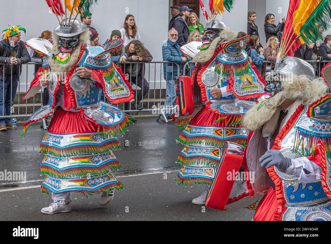 Bolivianische Tänzer in bunten Kostümen nehmen an der Prozession bei der St. Patrick's Day Parade in London Teil. Stockfoto