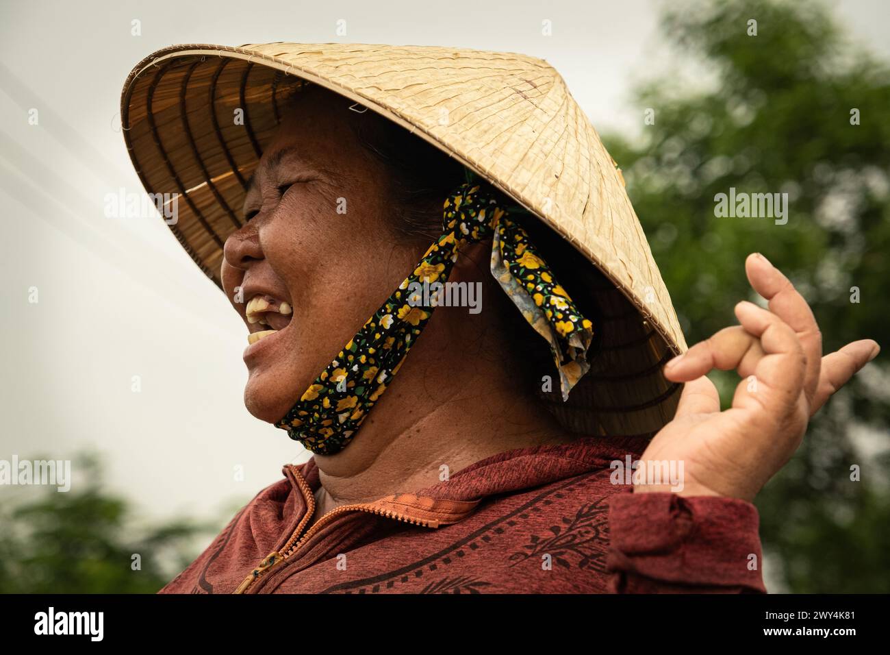 Bauernfrau auf dem Reisfeld lacht. Porträt eines glücklichen vietnamesischen Bauern auf dem Reisfeld. Frauen mit vietnamesischem Hut. Nicht-La Stockfoto