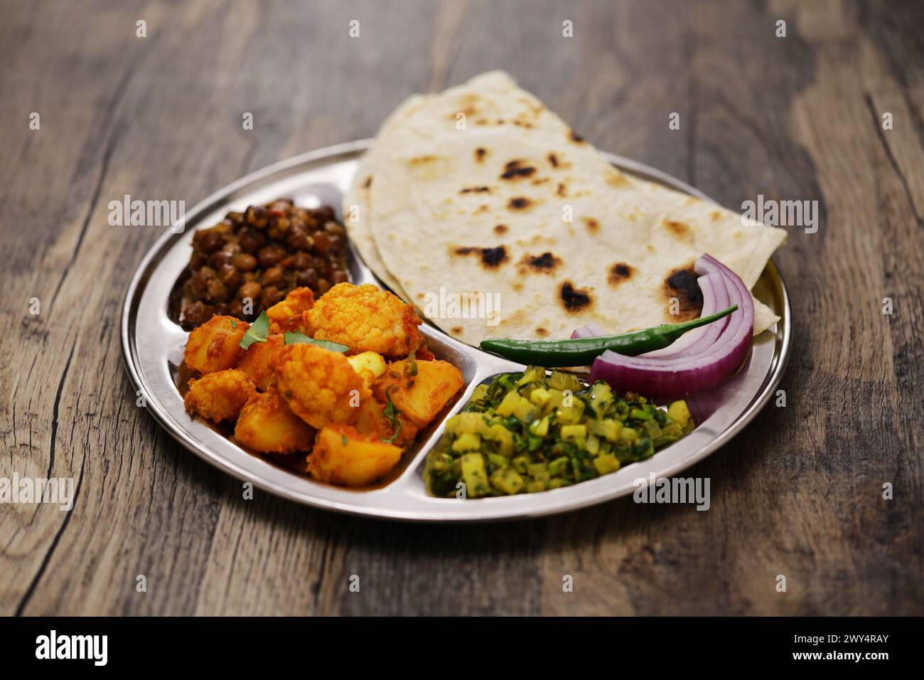 Indische vegetarische Platte. kala chana Masala, Aloo gobi KI Sabzi, Mooli KI Sabzi und Chapati. Stockfoto
