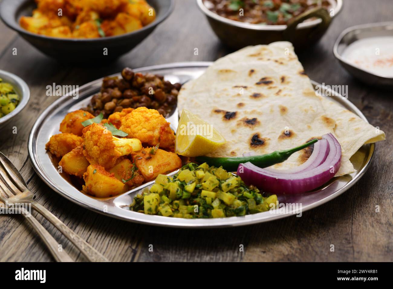 Indische vegetarische Platte. kala chana Masala, Aloo gobi KI Sabzi, Mooli KI Sabzi und Chapati. Stockfoto