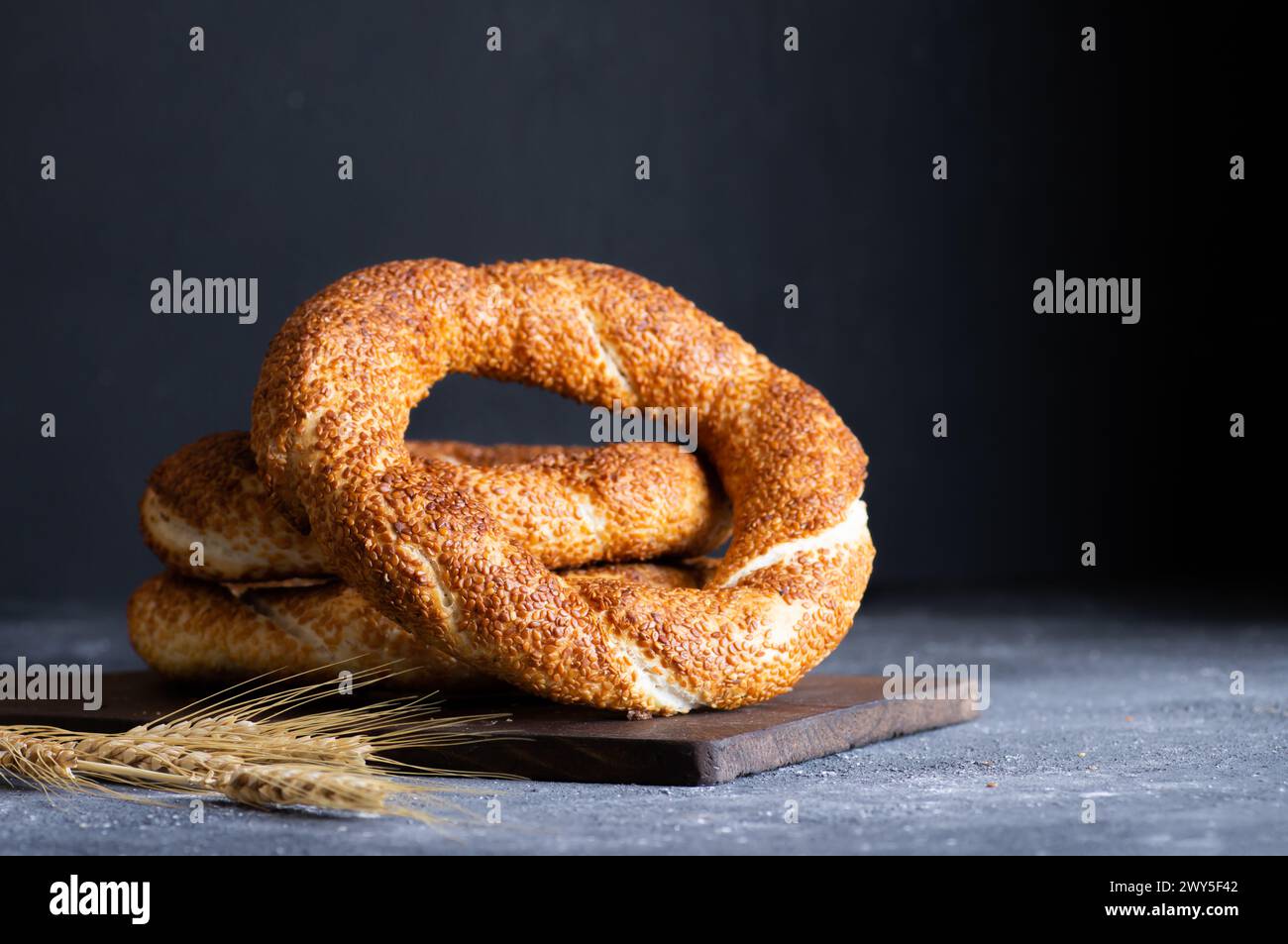 Traditioneller türkischer Bagel/Simit mit Sesam auf rustikalem Tisch, türkisches Frühstücksgebäck-Konzept Stockfoto