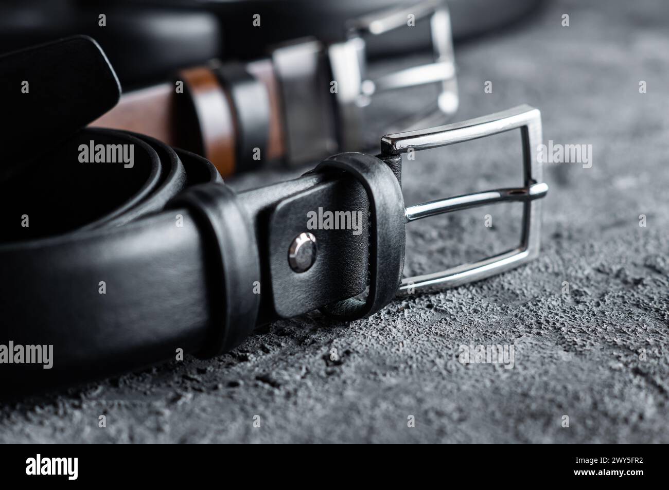 Stoffhose Kunstledergürtel auf rustikalem Steinhintergrund, Mode-Stil Stockfoto