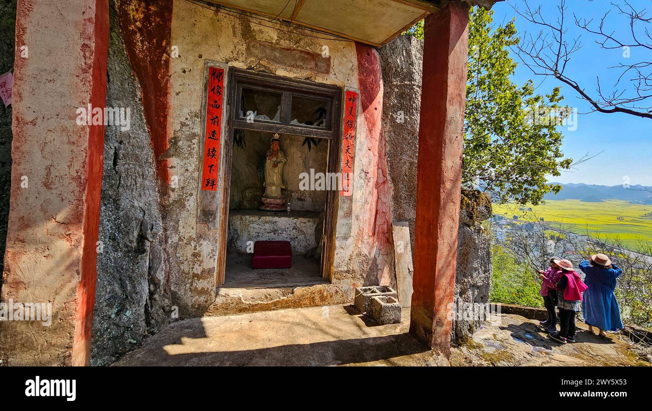 Einige Leute erkunden in einem kleinen, alten, baufälligen Gebäude in Loupin Rooster Hills, China Stockfoto
