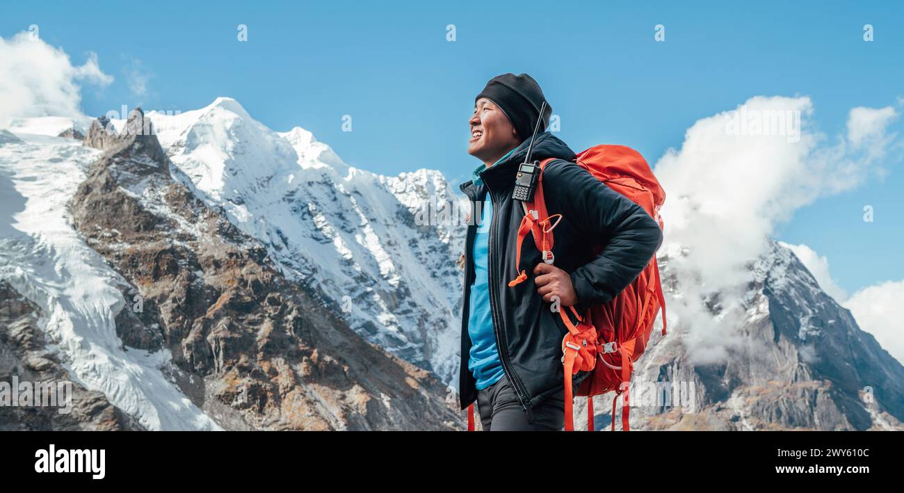 Porträt eines lächelnden Sherpa-Mannes mit Rucksack und Blick auf die Berge und die frische Luft mit dem 6476 m hohen Mera-Gipfel. Himalaya-Expedition während m Stockfoto