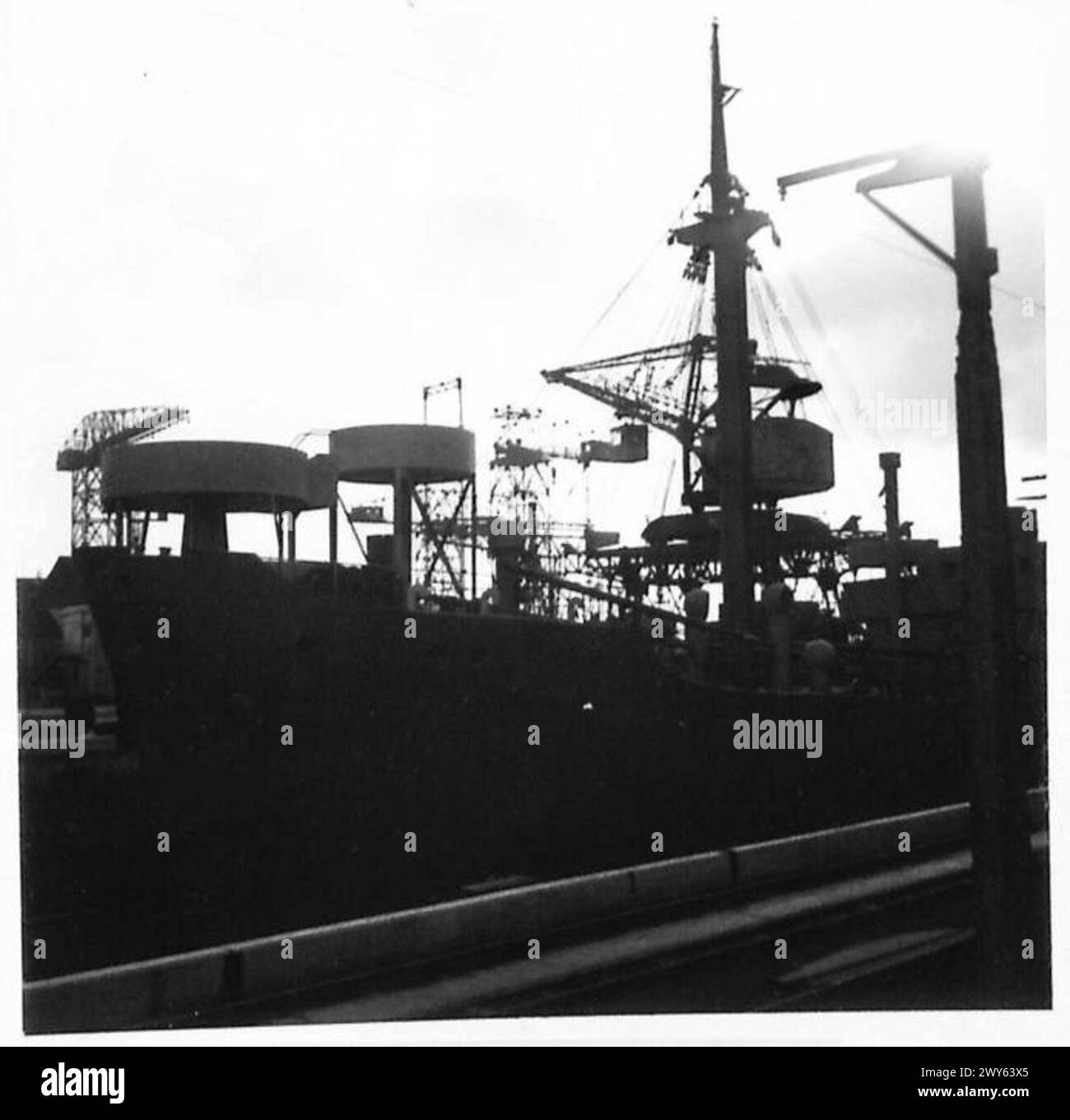 Im belgischen Hafen von Antwerpen liegen ungenutzte Schiffe vor Anker, mit Sturmwolken darüber, die die Kriegsbedingungen während des Zweiten Weltkriegs unter der britischen Armee, 21. Armeegruppe, widerspiegeln. Stockfoto