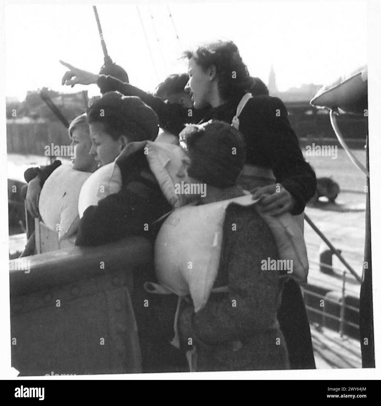 Niederländische Kinder werden auf einem Schiff nach England evakuiert, wobei ein Sektionsführer auf interessante Merkmale aufmerksam macht, während das Schiff den Festlandshafen unter Aufsicht der britischen Armee 21st Army Group verlässt. Stockfoto
