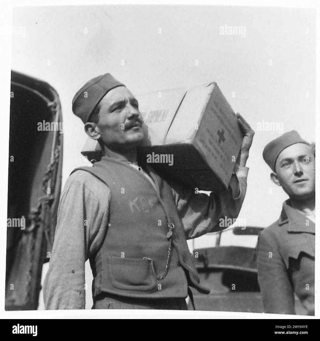 Eine jugoslawische Person führt während der Verteilung unter Aufsicht der britischen Armee ein Rotes Kreuz-Nahrungsmittelpaket. Stockfoto