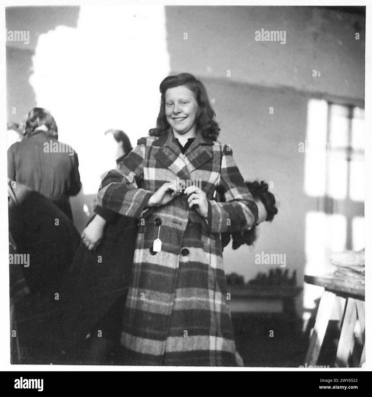 Ein niederländisches Mädchen modelliert einen neuen Mantel der alliierten Streitkräfte, der die Hilfe nach der Befreiung während des Zweiten Weltkriegs illustriert Stockfoto