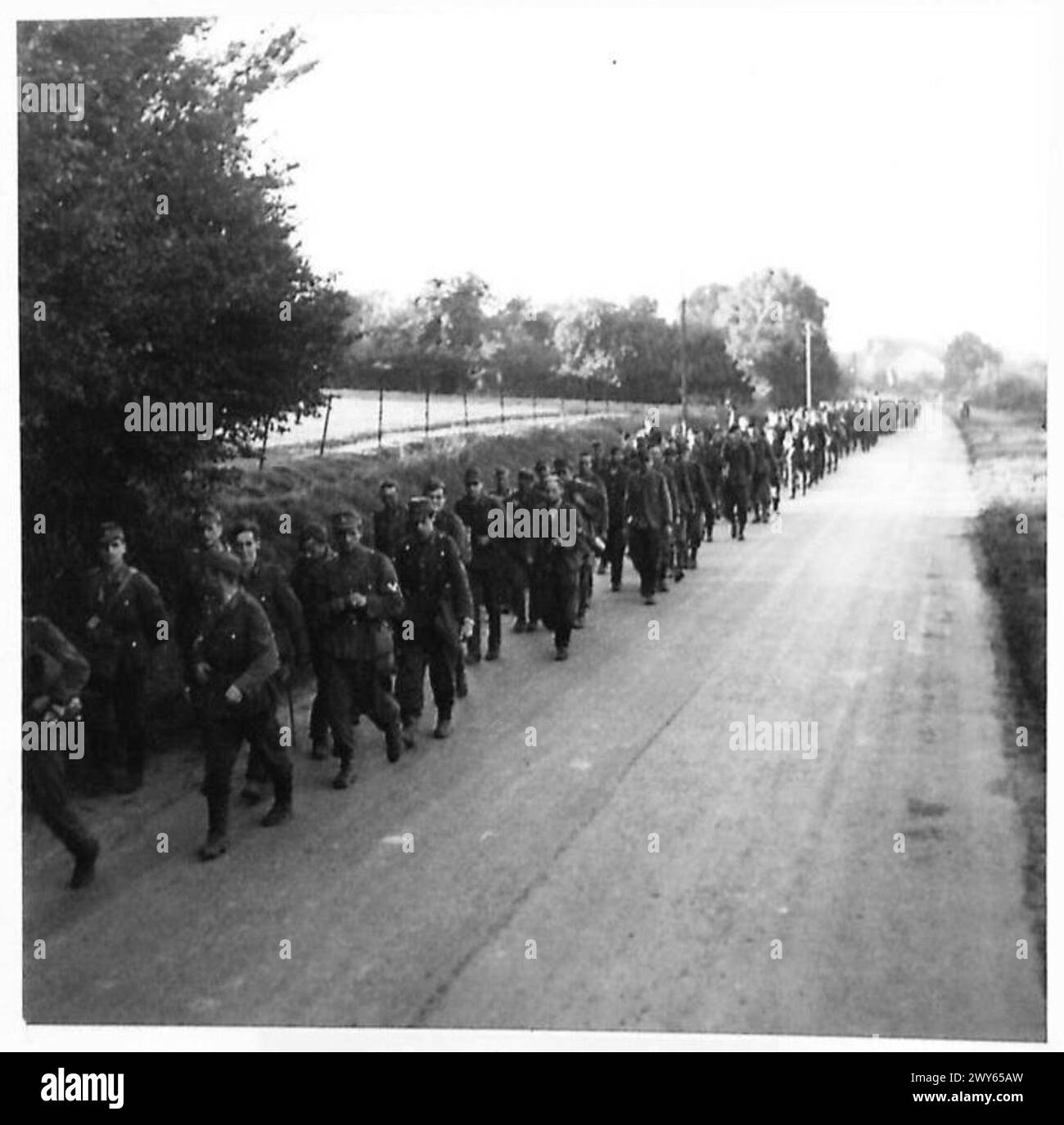Etwa 400 erschöpfte deutsche Soldaten werden während des britischen Vormarsches im Zweiten Weltkrieg durch die Straßen von Abbeville nach Granvilliers marschiert Stockfoto