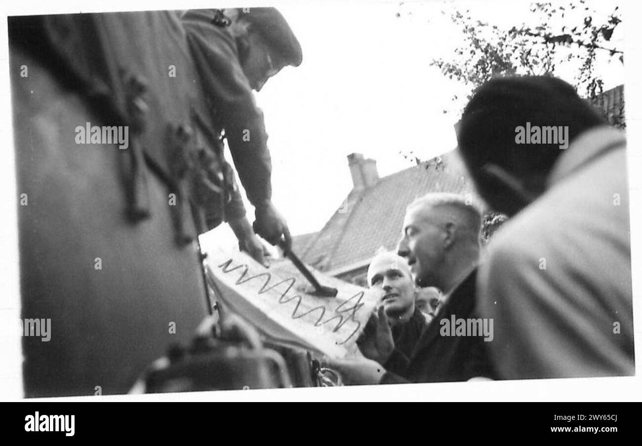 Major Gordon verwendet einen kleinen Hammer, um Positionen auf einer Karte während der Befreiung Dirschots unter der Aufsicht der britischen Armee, der 21. Armee, anzuzeigen. Stockfoto