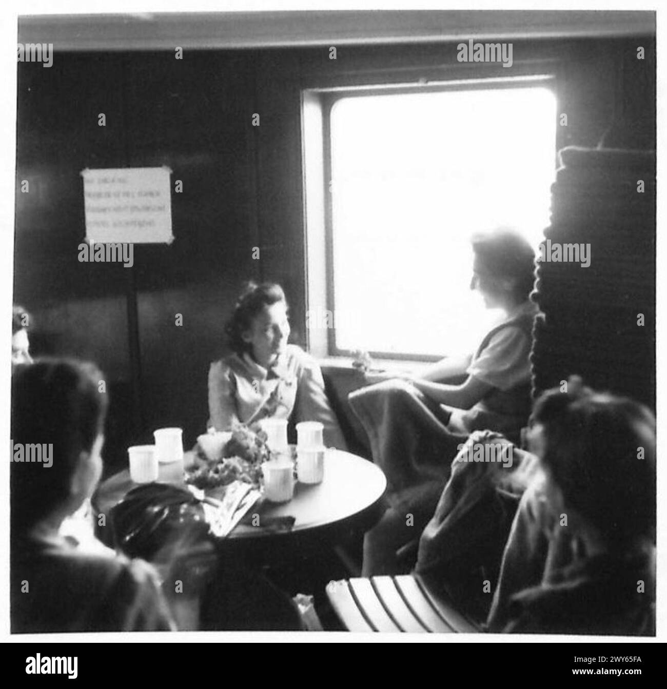 Eine Gruppe ungarischer Überlebender wird während des Transports vom Konzentrationslager Belsen nach Schweden unter Aufsicht der britischen Armee, 21. Armeegruppe, an einem Schiffsfenster gesehen. Stockfoto