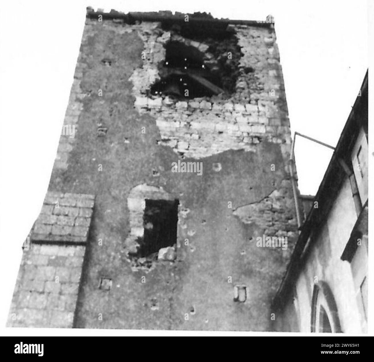 Ein beschädigter Kirchturm in Benouville nach dem Artilleriebeschuss der britischen Armee neutralisierte deutsche Scharfschützen während der Operationen in Nordwesteuropa (1944–1945). Stockfoto