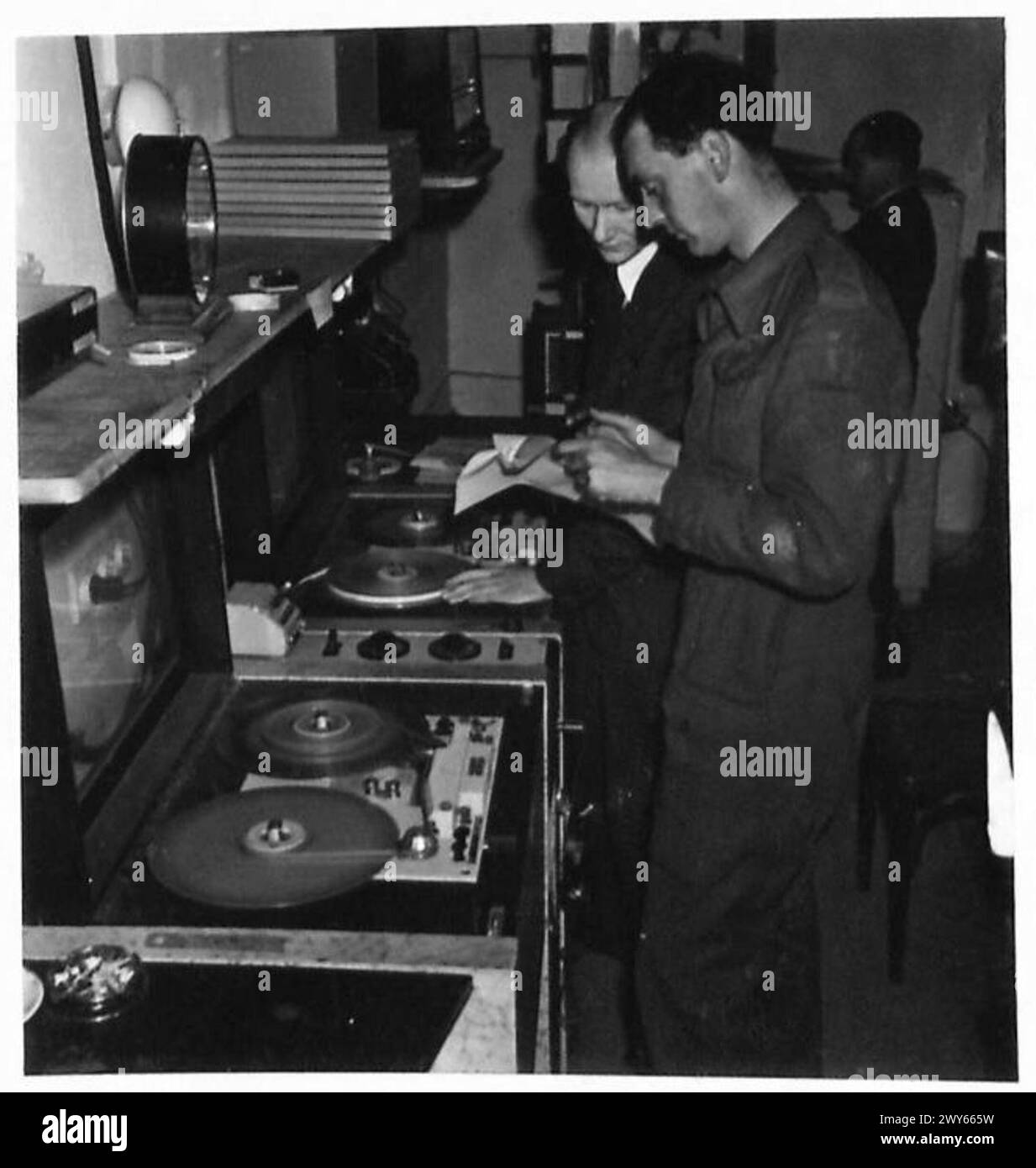 Ein Second Army Documents Team überprüft die Akten von William Joyces Offizier beim Reichsender Hamburg, einschließlich Reden und Auszügen britischer Kriegsgefangener, die nun von der britischen Armee, 21st Army Group, betrieben werden. Stockfoto