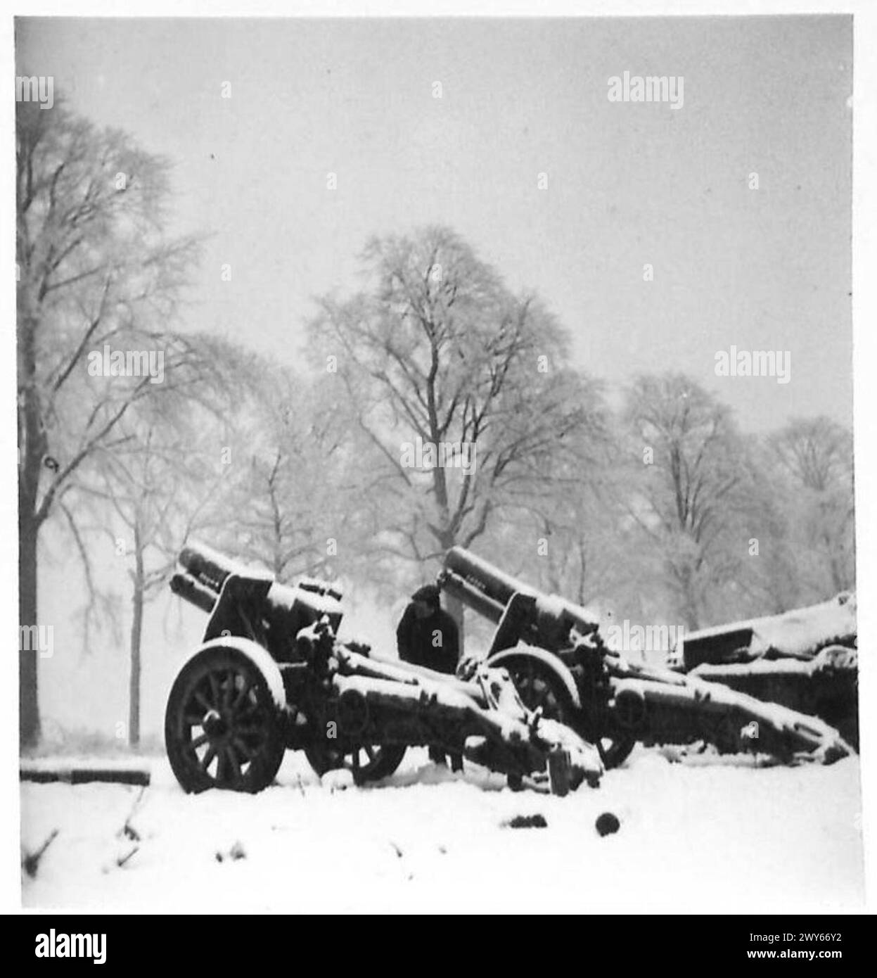 Ein britischer Soldat inspiziert schwere Artillerie, die von deutschen Truppen während ihres Rückzugs an der Westfront im Zweiten Weltkrieg unter der britischen Armee, 21st Army Group, verlassen wurde. Stockfoto