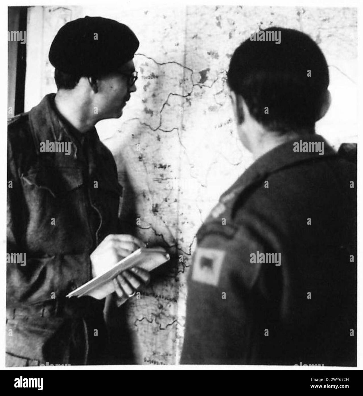 Captain J.W. Gray von der Phantom-Patrouille, 11. Panzerdivision, spricht mit dem G.2-Operationsoffizier über operative Punkte auf der Karte. Stockfoto