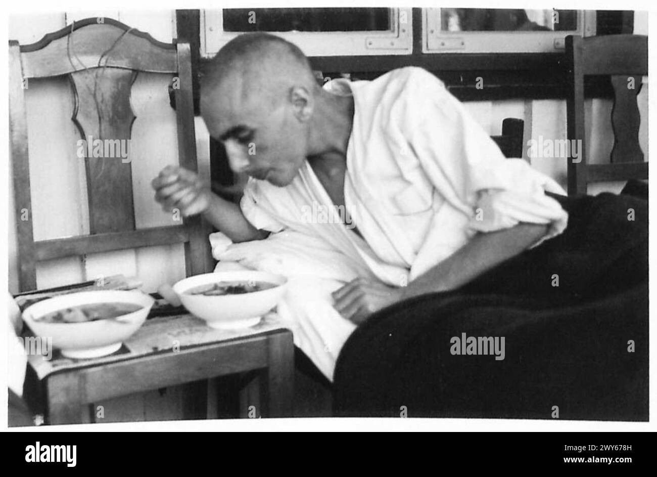 Der französische politische Gefangene Munier Rene isst sein Krankenhausessen in Dänemark, während er während des Zweiten Weltkriegs unter der Aufsicht der britischen Armee der 21. Armee steht Stockfoto