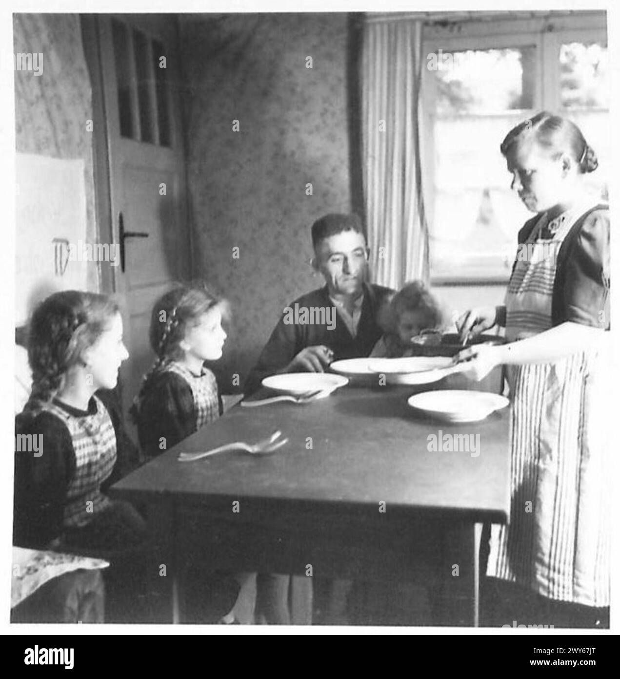 Eine norddeutsche Bergarbeiterfamilie isst Kartoffelpüree und Rüben unter Kohlekontrolle. Stockfoto