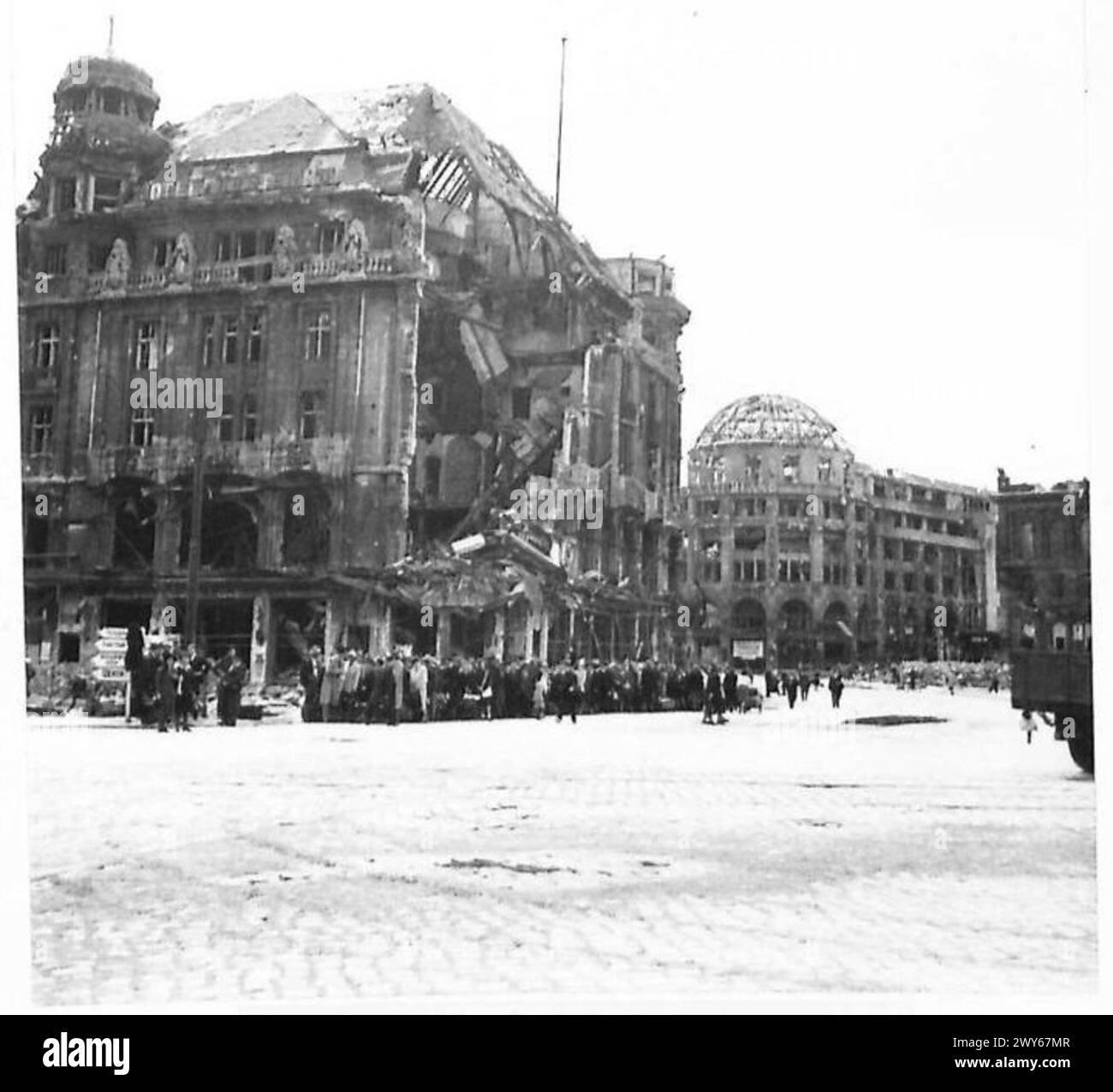 BOMBENSCHADEN IN BERLIN BESEITIGEN - nach ihrer täglichen Arbeit warten die Berliner in langen Warteschlangen Stunden auf die wenigen Busse. Britische Armee, 21. Armeegruppe Stockfoto
