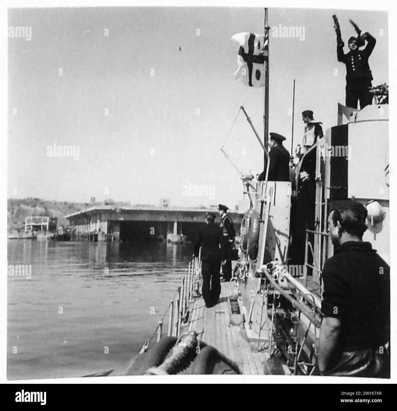 Ein Schiff, das den Admiral trägt, nähert sich Helgoland mit dem Admiral, der unter der Flagge steht, was die Übergabe an die britischen Streitkräfte, 21. Armeegruppe, markiert. Stockfoto