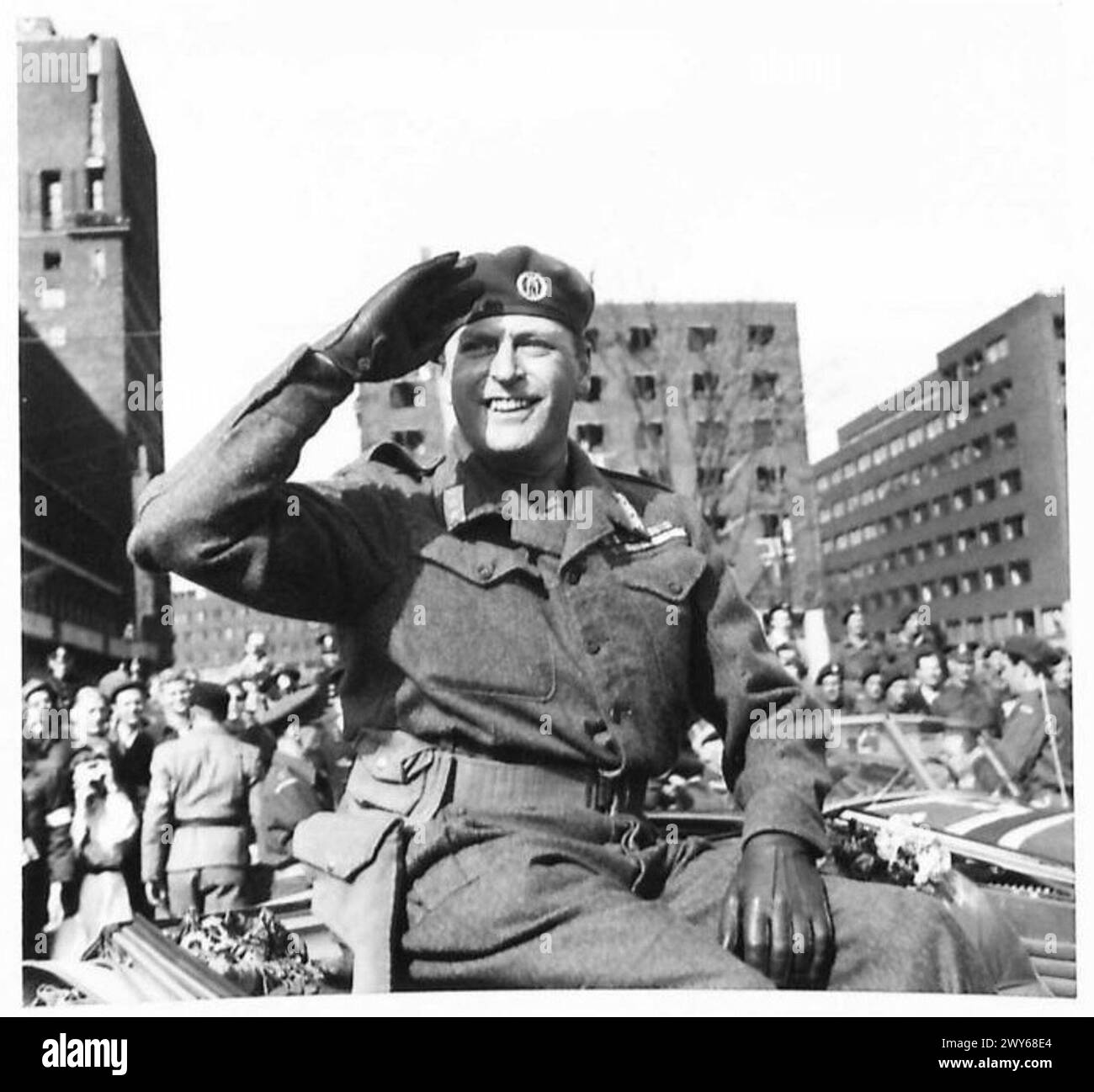 Kronprinz Olav kehrt nach Norwegen zurück und grüßt die Menge während einer zeremoniellen Ankunft auf der Rückseite seines Autos. Stockfoto