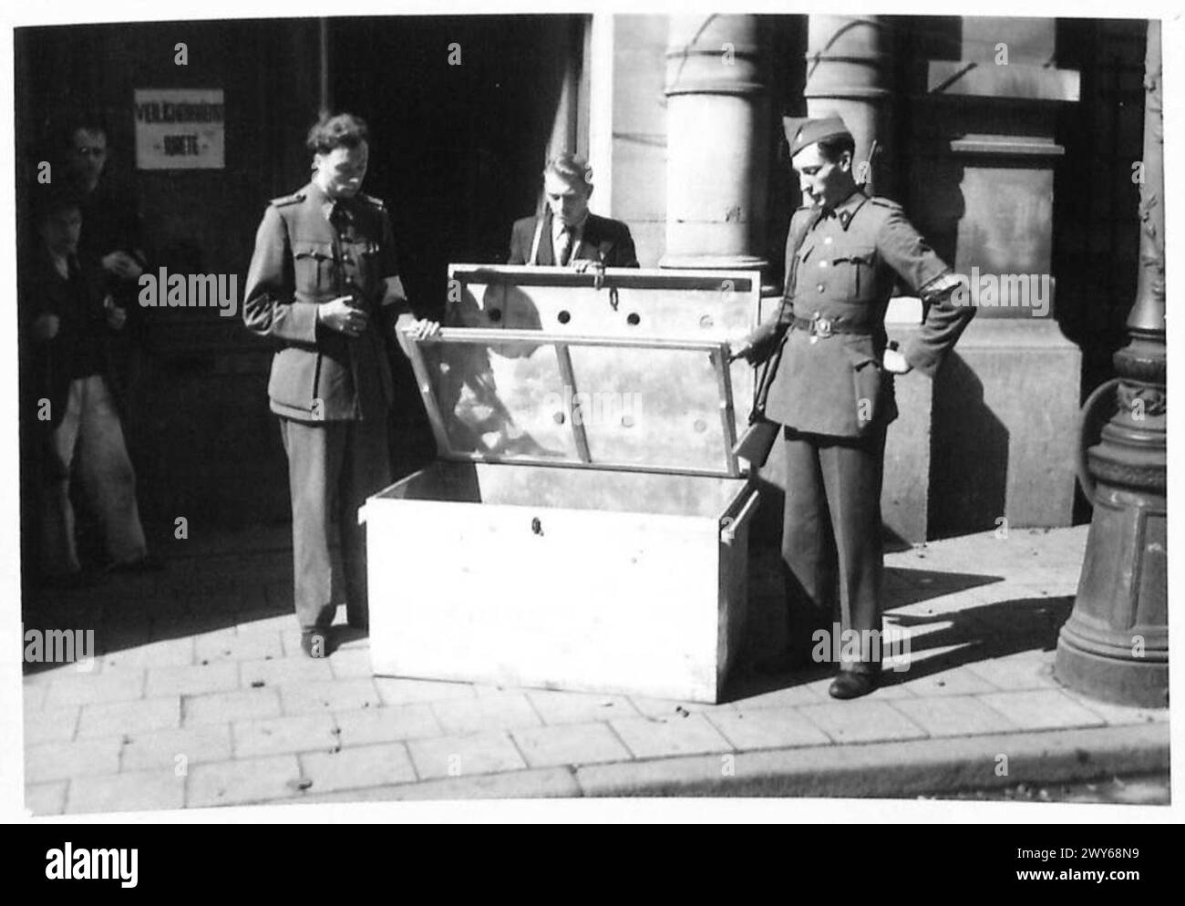 DEUTSCHE GRÄUELTATEN UND FOLTER GEGEN DAS BELGISCHE VOLK. - Männer der Brigade Blanche untersuchen die Kiste. Britische Armee, 21. Armeegruppe Stockfoto