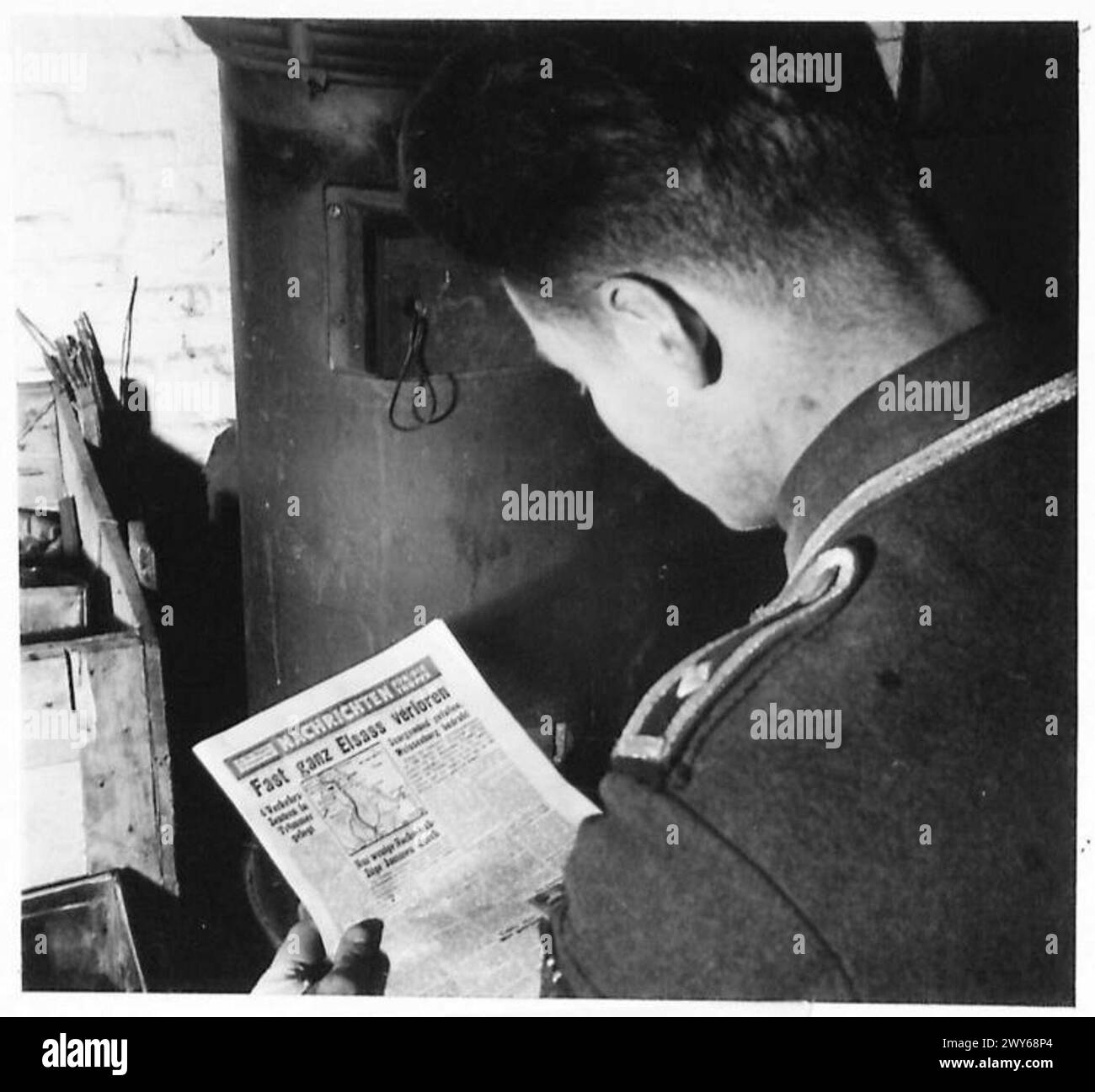 Ein deutscher NCO liest eine spezielle deutsche Zeitung, die für Kriegsgefangene (Kriegsgefangene) gedruckt wird und die Informationsverteilung innerhalb der Kriegsgefangenenlager veranschaulicht. Stockfoto