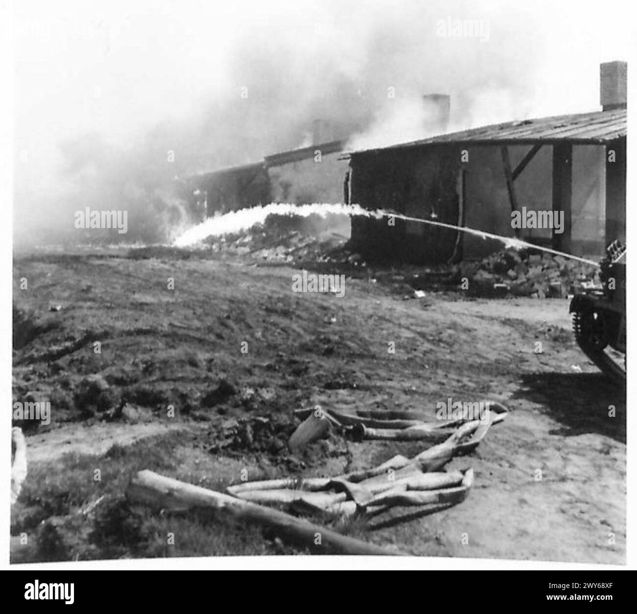 Das Konzentrationslager Belsen wird mit Flammenwerfer als Teil des Abrisses in Brand gesetzt, wobei die britische Armee und die 21. Armeegruppe die Operation nach der Befreiung überwachen. Stockfoto
