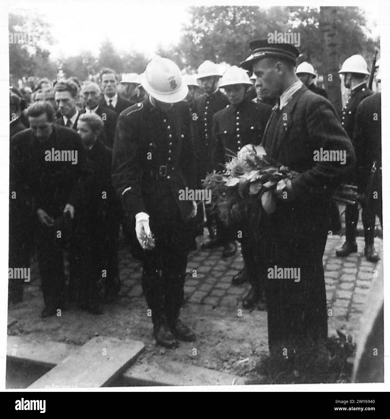 Belgische Polizisten nehmen an einer zeremoniellen Beerdigung in Brüssel Teil und legen Blumen auf die Gräber von Polizisten, die von deutschen Truppen getötet wurden. Stockfoto