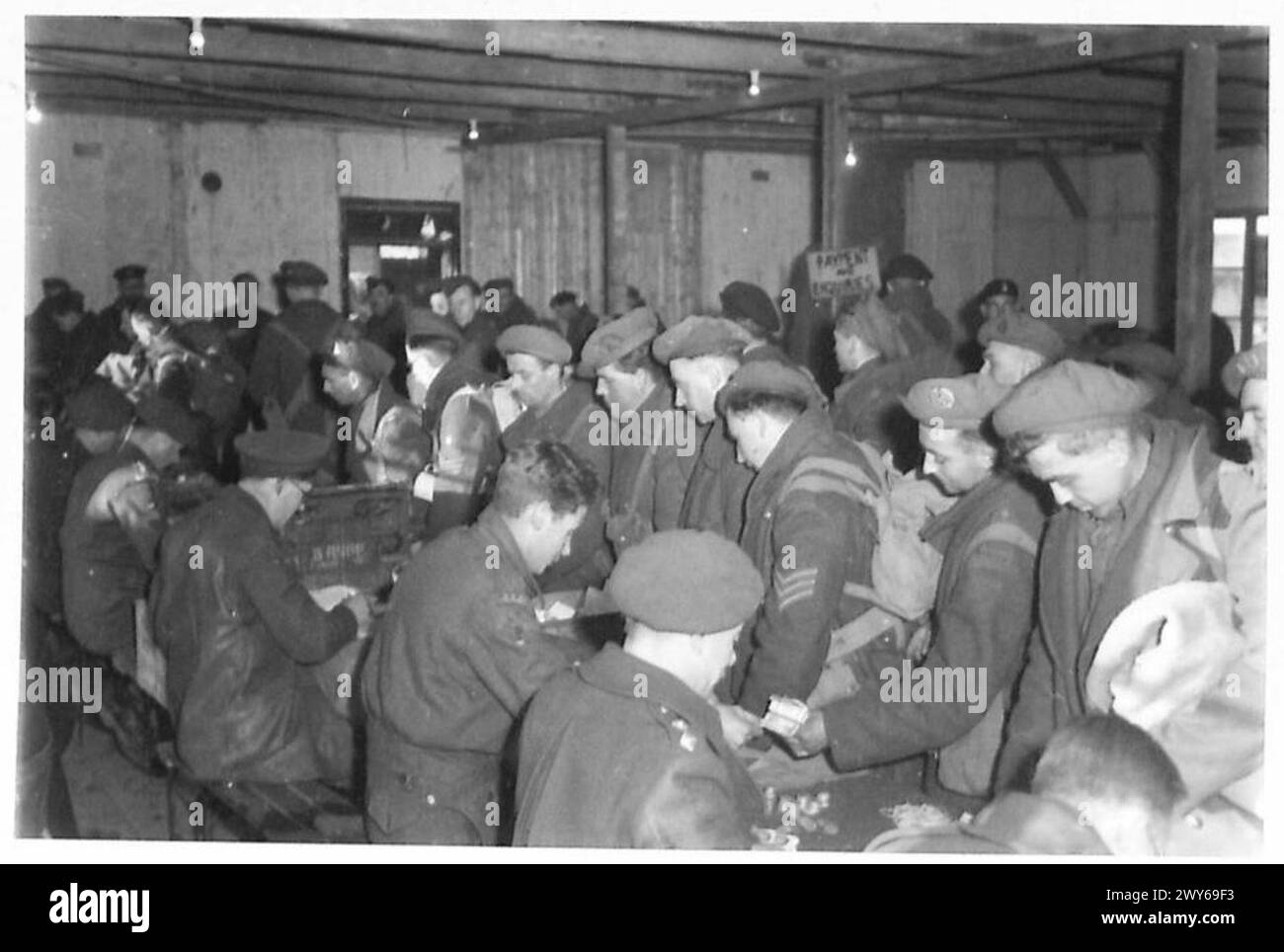 Britische Soldaten, die nach dem D-Day auf dem ersten Boot nach Hause zurückkehren, wechseln Geld bei der Ankunft im Hafen während der Operationen der britischen Armee. Stockfoto